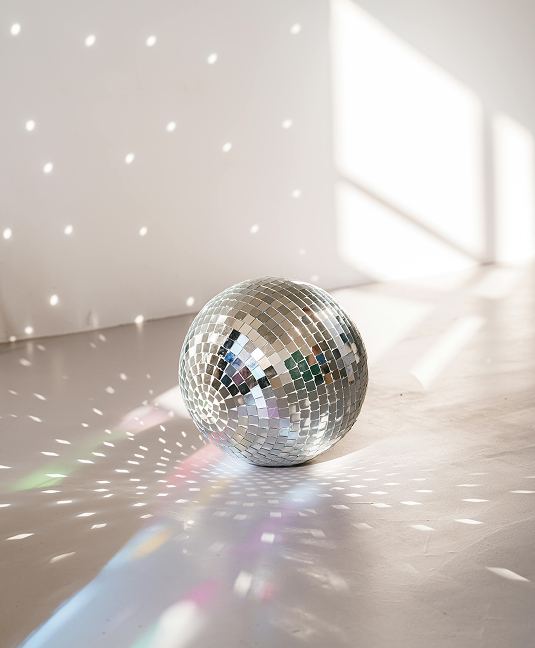 Silver disco ball reflecting light on wall and floor